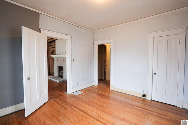 unfurnished bedroom featuring a fireplace and light wood-type flooring