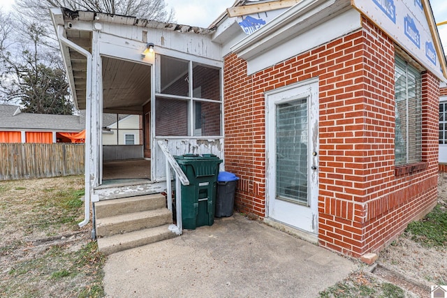 view of exterior entry with a patio