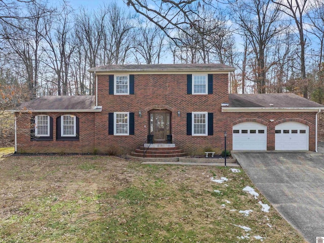 colonial-style house featuring a garage and a front lawn