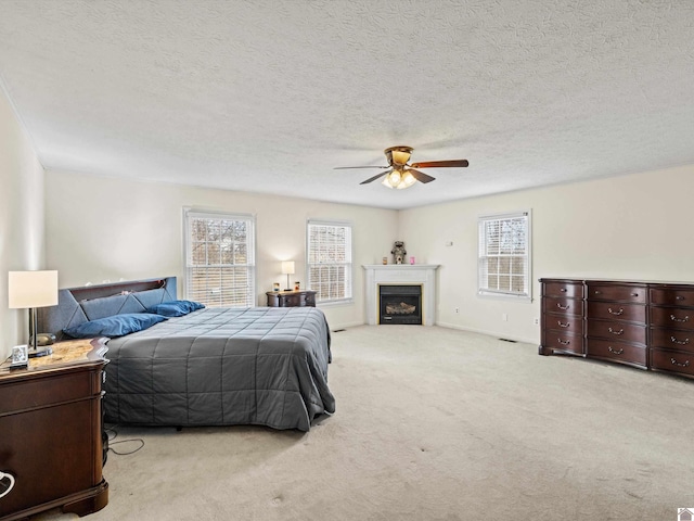 carpeted bedroom with a textured ceiling and ceiling fan