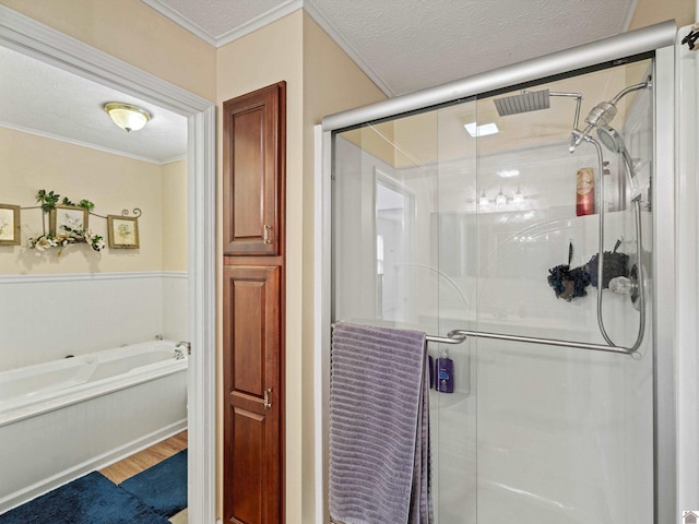 bathroom with ornamental molding, shower with separate bathtub, hardwood / wood-style floors, and a textured ceiling