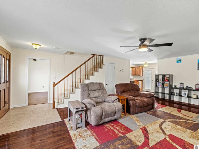 living room with ceiling fan, light hardwood / wood-style flooring, and a textured ceiling