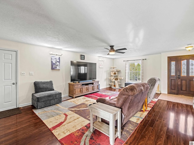 living room with hardwood / wood-style flooring, ceiling fan, and a textured ceiling