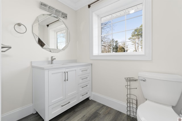 bathroom featuring crown molding, wood-type flooring, toilet, and a healthy amount of sunlight