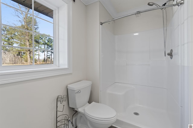 bathroom featuring a shower, crown molding, and toilet