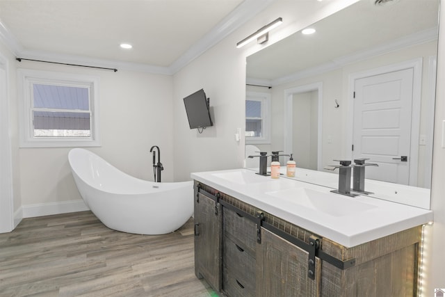 bathroom with vanity, wood-type flooring, ornamental molding, and a bathing tub