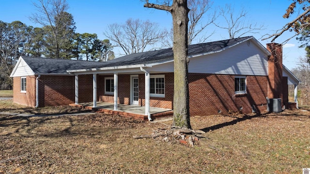 view of front facade featuring cooling unit, a patio area, and a front lawn