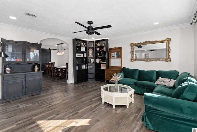 living room with crown molding, ceiling fan, dark hardwood / wood-style floors, and a textured ceiling