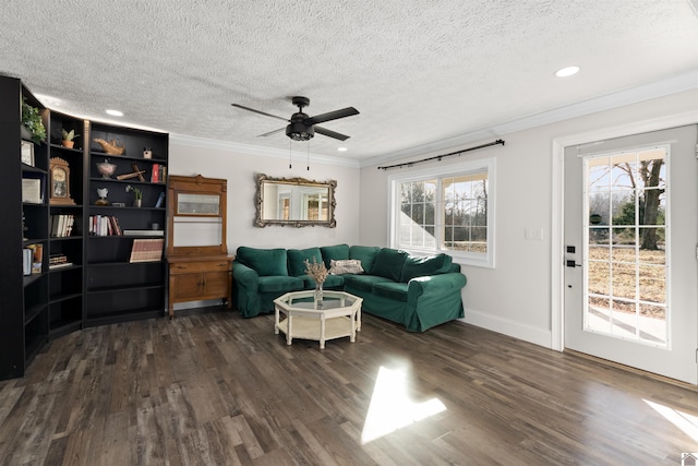 living room with ornamental molding, dark wood-type flooring, ceiling fan, and a textured ceiling