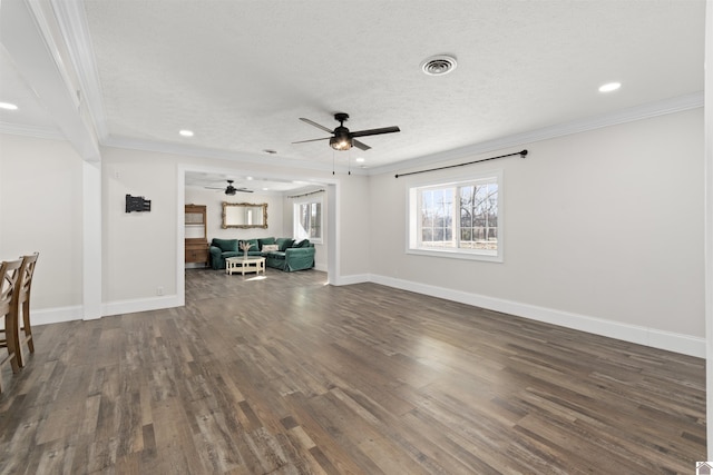 unfurnished living room featuring dark wood-type flooring, ornamental molding, and a textured ceiling