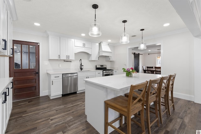 kitchen with pendant lighting, white cabinetry, sink, stainless steel appliances, and dark wood-type flooring