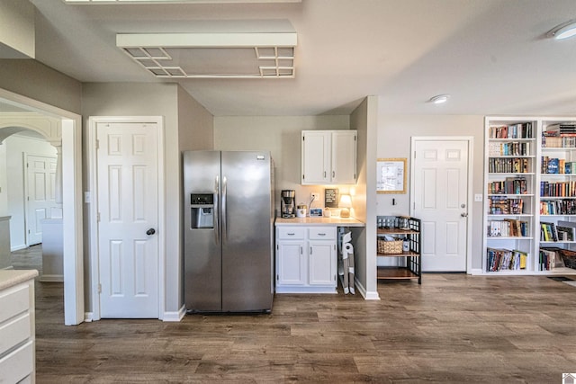 kitchen with stainless steel fridge, dark hardwood / wood-style floors, and white cabinets