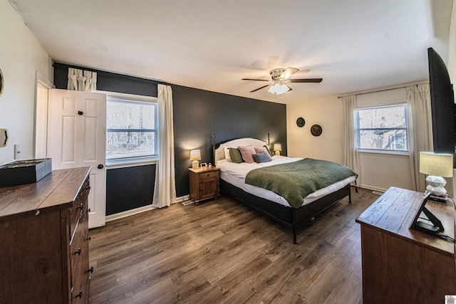 bedroom with multiple windows, dark hardwood / wood-style flooring, and ceiling fan