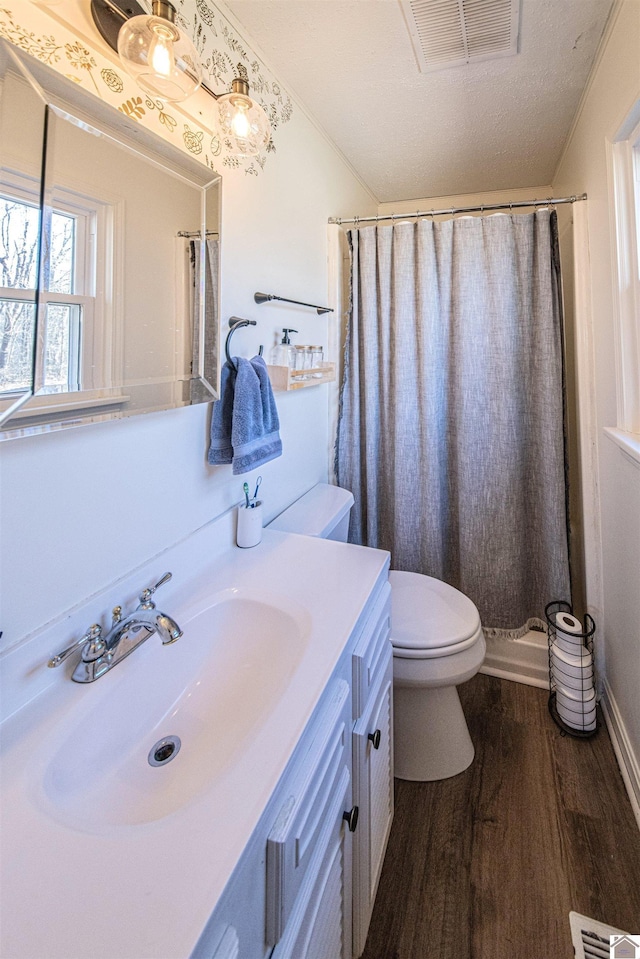 bathroom with vanity, wood-type flooring, a textured ceiling, a shower with curtain, and toilet