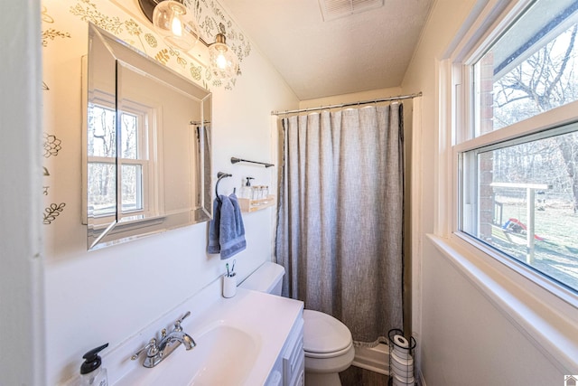 bathroom with walk in shower, vanity, toilet, and a textured ceiling