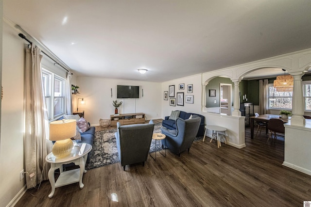 living room with decorative columns and dark hardwood / wood-style floors