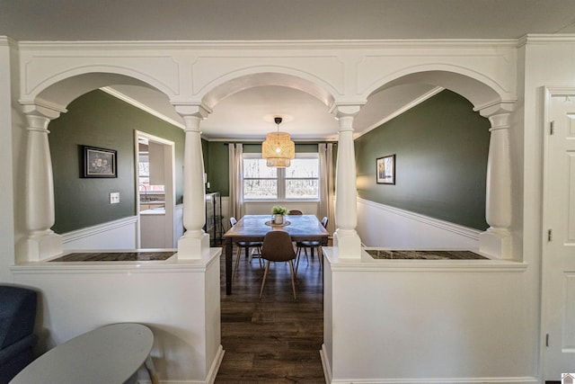 dining area with decorative columns, ornamental molding, and dark hardwood / wood-style floors