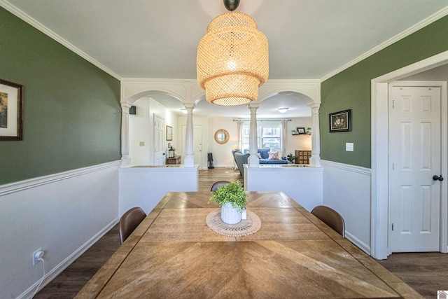 dining room with decorative columns, crown molding, and dark hardwood / wood-style floors