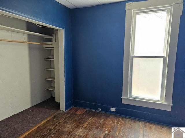 unfurnished bedroom featuring dark wood-type flooring and a closet