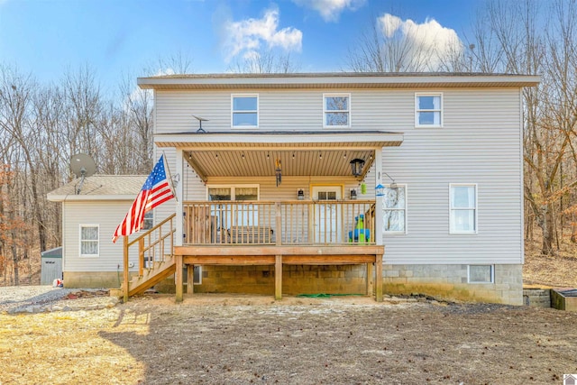 rear view of property featuring a wooden deck