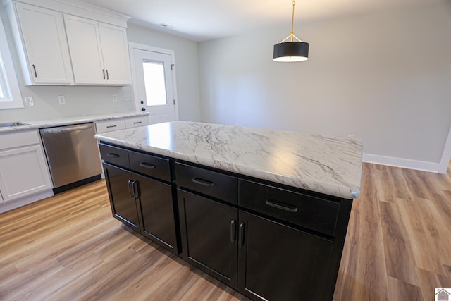 kitchen with white cabinetry, stainless steel dishwasher, decorative light fixtures, and a kitchen island