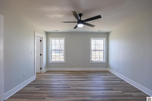 spare room with ceiling fan, dark hardwood / wood-style floors, and a wealth of natural light