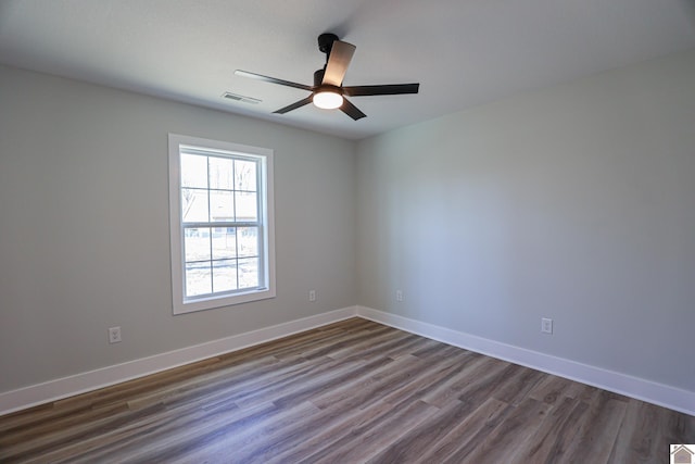 empty room featuring dark wood-type flooring and ceiling fan