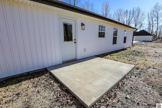 view of exterior entry with a patio