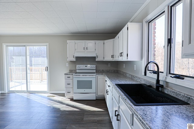 kitchen featuring white electric stove, white cabinetry, sink, and a wealth of natural light