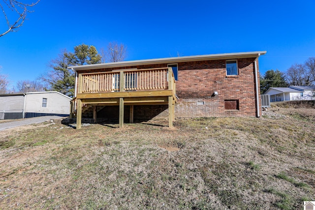 back of house with a wooden deck and a lawn