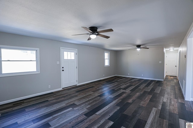 interior space featuring dark wood-type flooring, ceiling fan, and a textured ceiling