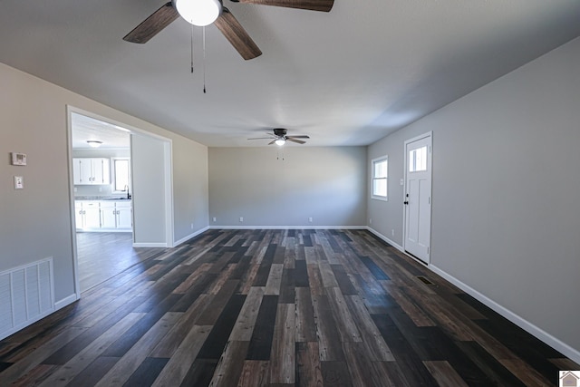 unfurnished living room with ceiling fan, dark hardwood / wood-style floors, and sink