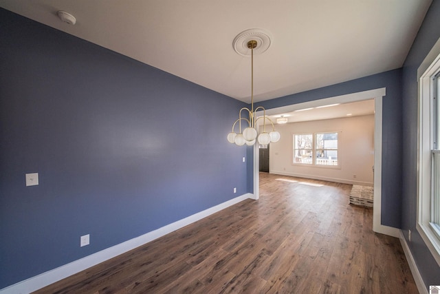 unfurnished dining area featuring dark hardwood / wood-style floors and an inviting chandelier