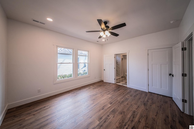 unfurnished bedroom featuring ceiling fan, dark hardwood / wood-style floors, and ensuite bath