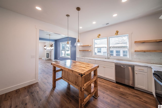 kitchen featuring sink, tasteful backsplash, hanging light fixtures, appliances with stainless steel finishes, and white cabinets