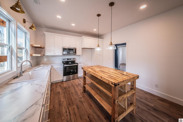 kitchen with white cabinetry, sink, backsplash, stainless steel appliances, and light stone countertops