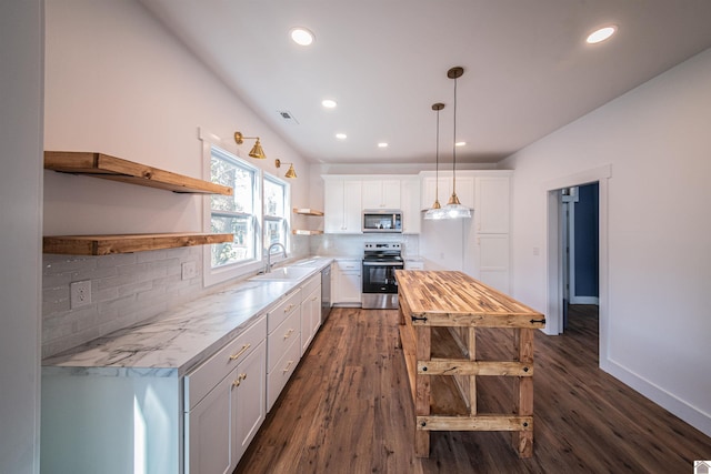 kitchen with pendant lighting, sink, appliances with stainless steel finishes, white cabinetry, and backsplash