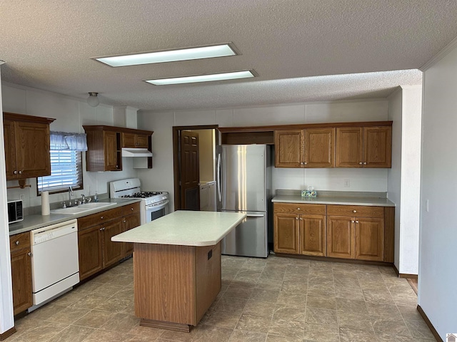 kitchen featuring sink, stainless steel appliances, a center island, and a textured ceiling