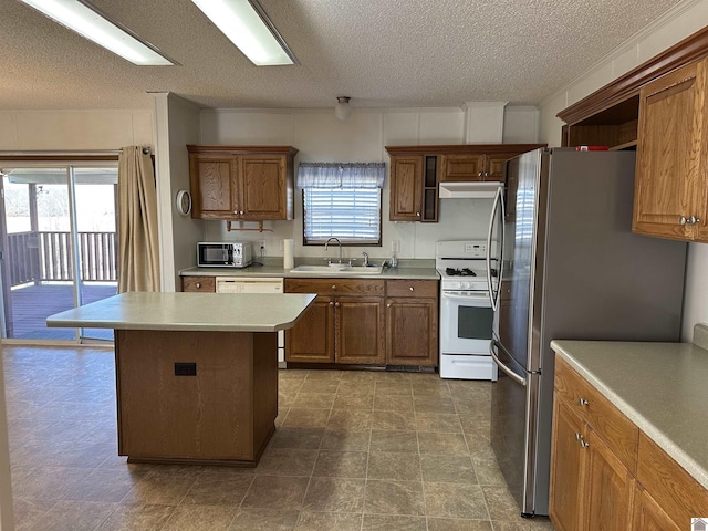 kitchen featuring a center island, sink, a textured ceiling, and white appliances