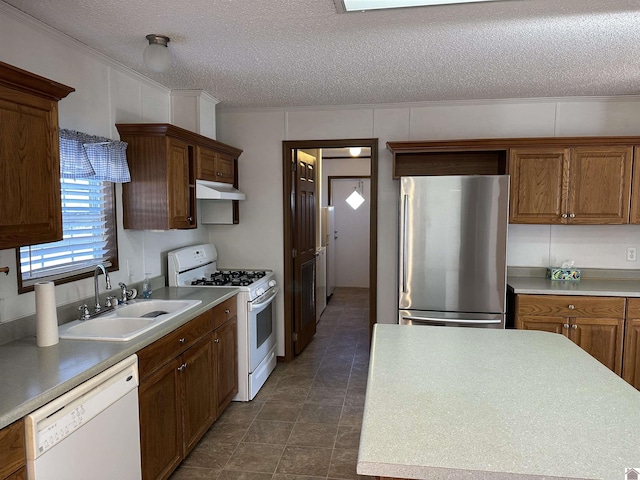 kitchen with crown molding, sink, white appliances, and a textured ceiling