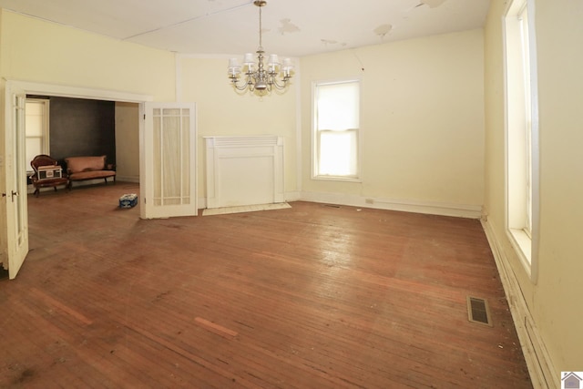 unfurnished dining area with a notable chandelier and dark hardwood / wood-style flooring