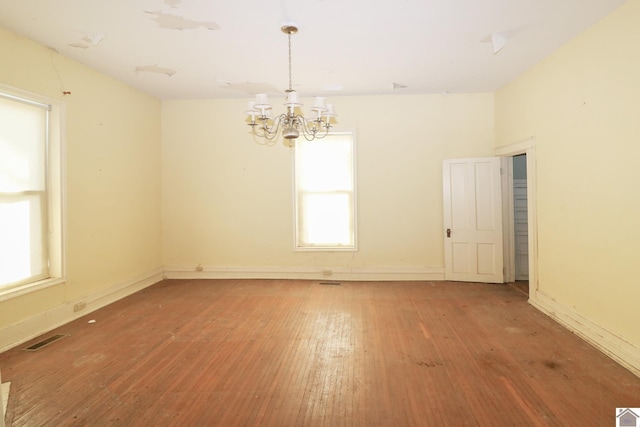 unfurnished room featuring wood-type flooring and a chandelier