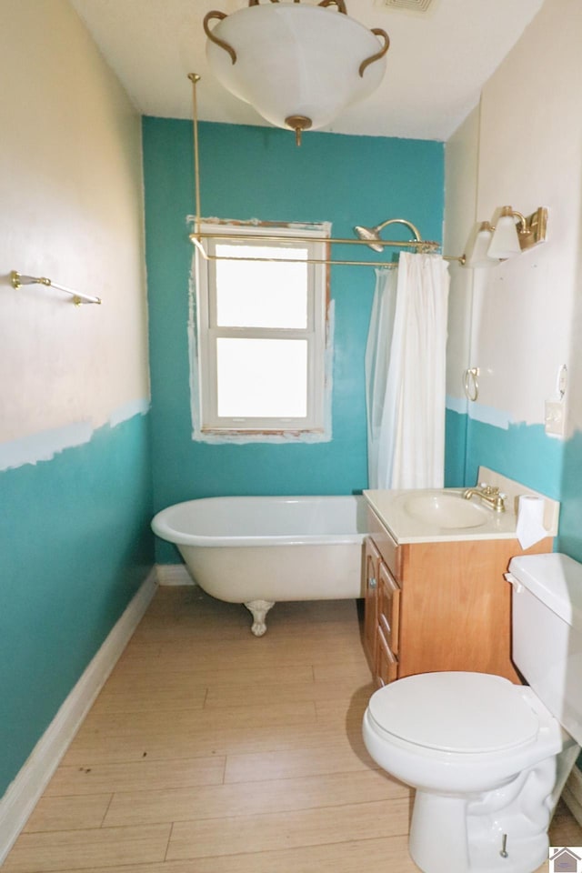 bathroom featuring wood-type flooring, vanity, a bathtub, and toilet