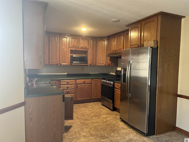 kitchen with sink, stainless steel appliances, and a textured ceiling