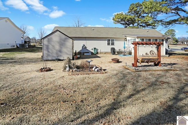 back of house with cooling unit, a pergola, and a fire pit