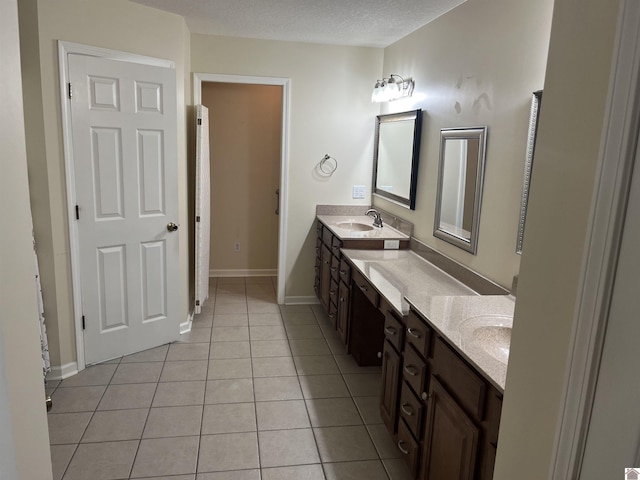 bathroom with tile patterned floors, a textured ceiling, and vanity