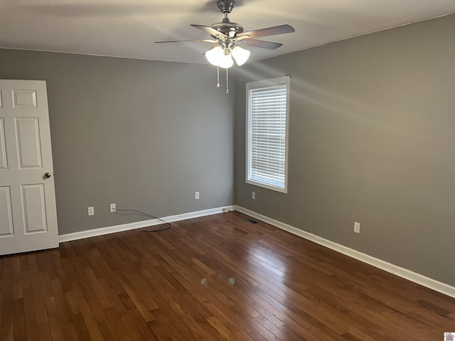 empty room featuring dark wood-type flooring and ceiling fan