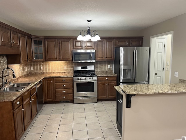 kitchen with sink, decorative light fixtures, kitchen peninsula, and appliances with stainless steel finishes