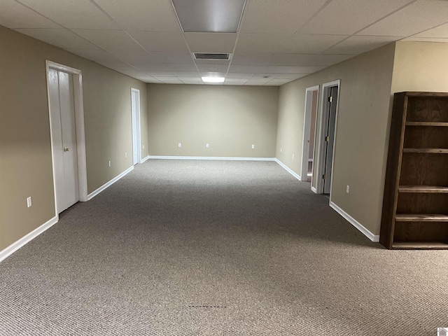 carpeted spare room featuring a drop ceiling