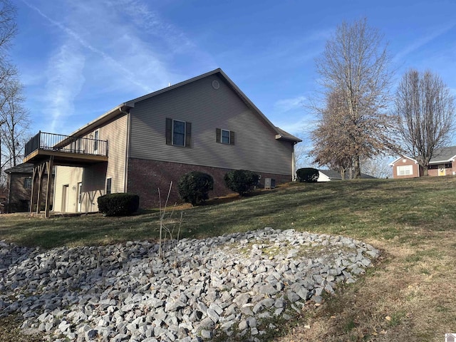 view of property exterior featuring a wooden deck and a lawn